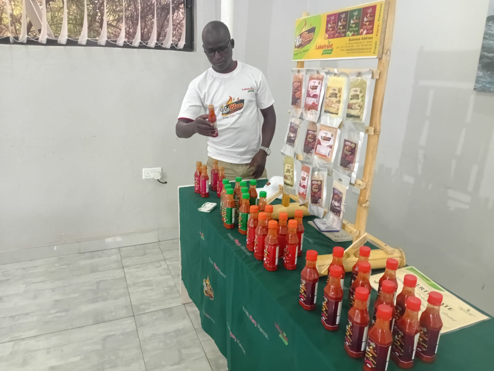 KaBlaze product stand with sauce bottles and packaging
